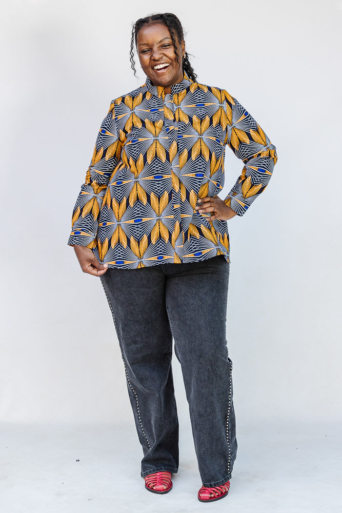Model wearing blue, white and yellow abstract print shirt.