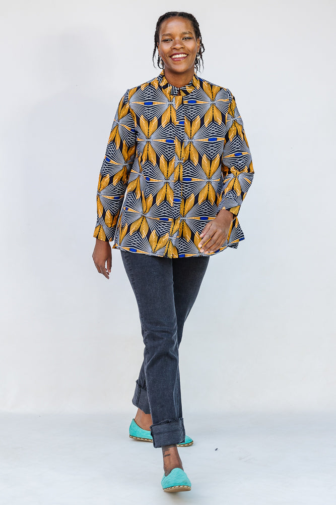 Model wearing blue, white and yellow abstract print shirt.