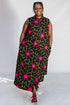 Model wearing navy and green dress with pink floral print.