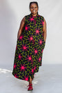 Model wearing navy and green dress with pink floral print.
