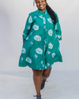 Model wearing teal dress with white cat print.