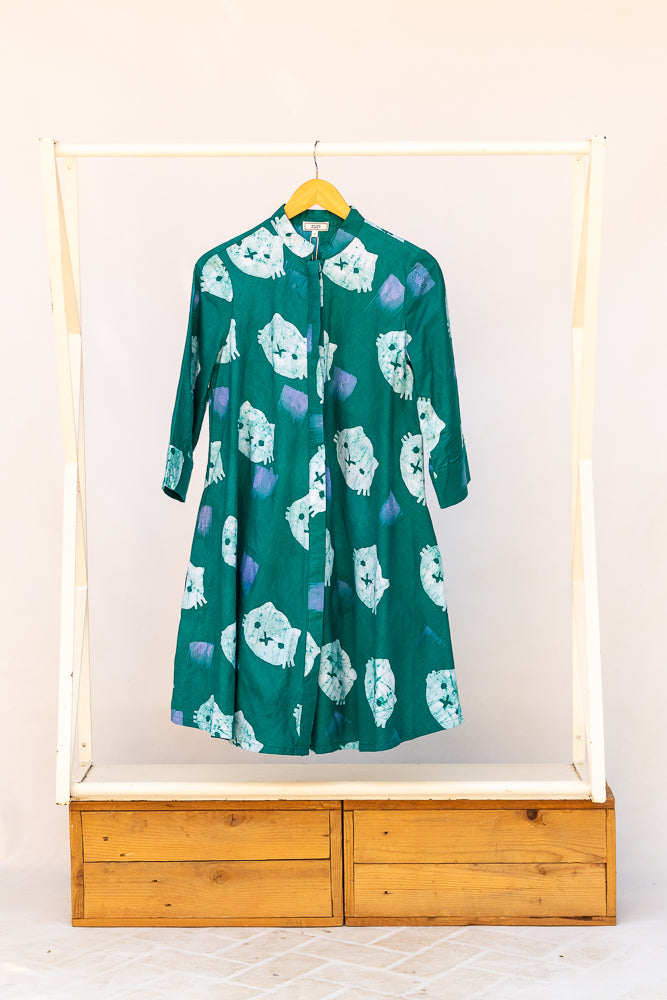 Display of teal dress with white cat print.