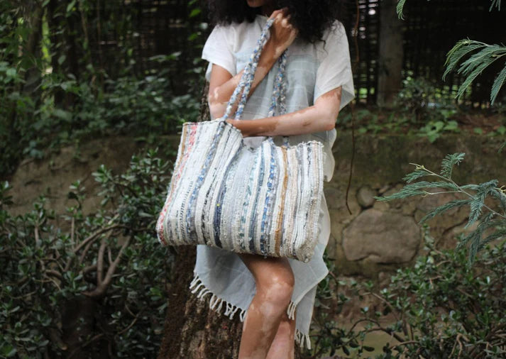 Person holding a patterned tote bag in a natural setting