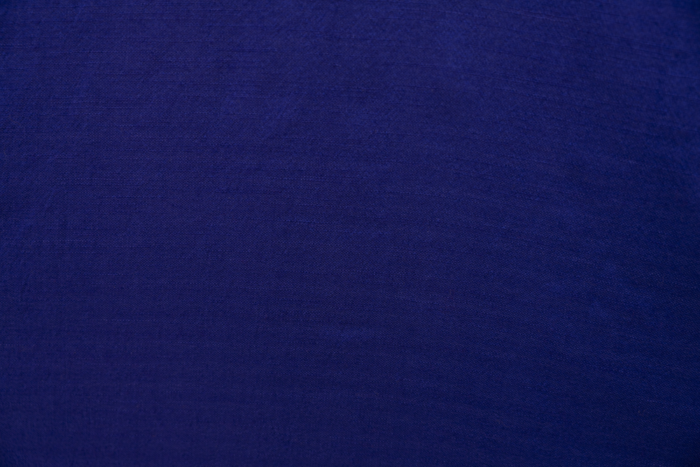 Close up display of deep blue linen dress, fabric.