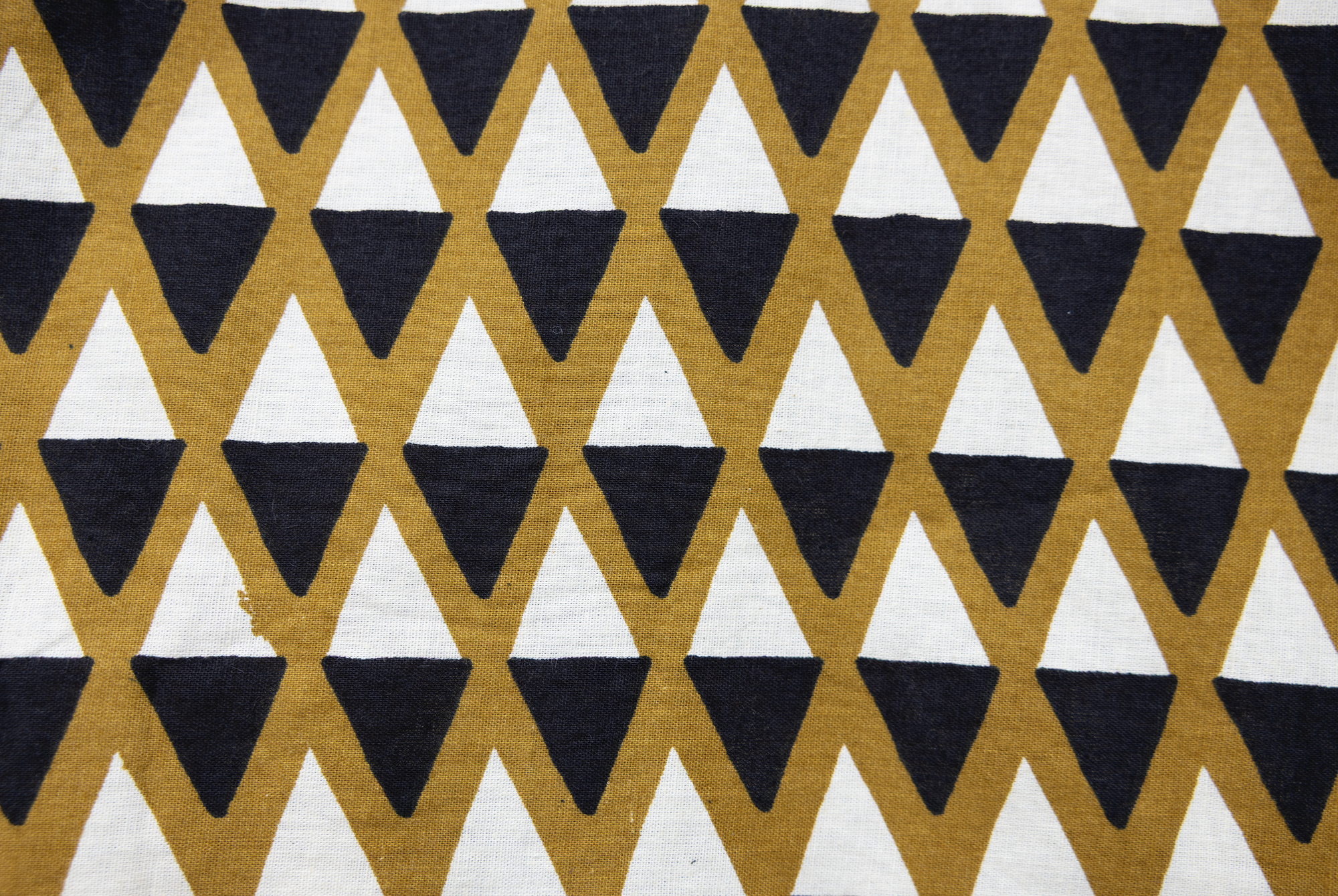 Close up display of black and white triangle print shirt, fabric.