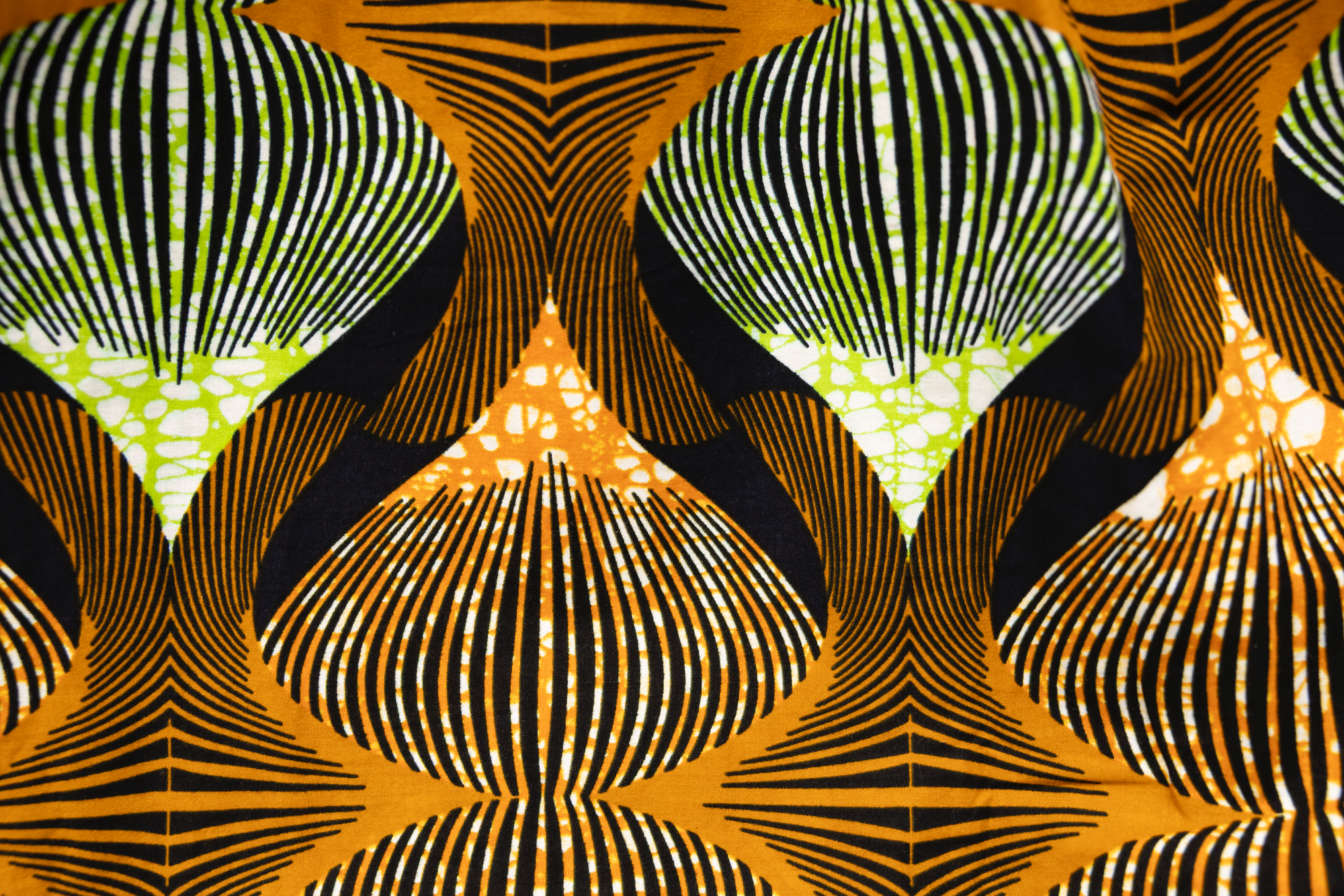 Close up display of orange and green geometric print pants, fabric.