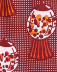 Close up display of red shirt with orange and white gumball print, fabric.