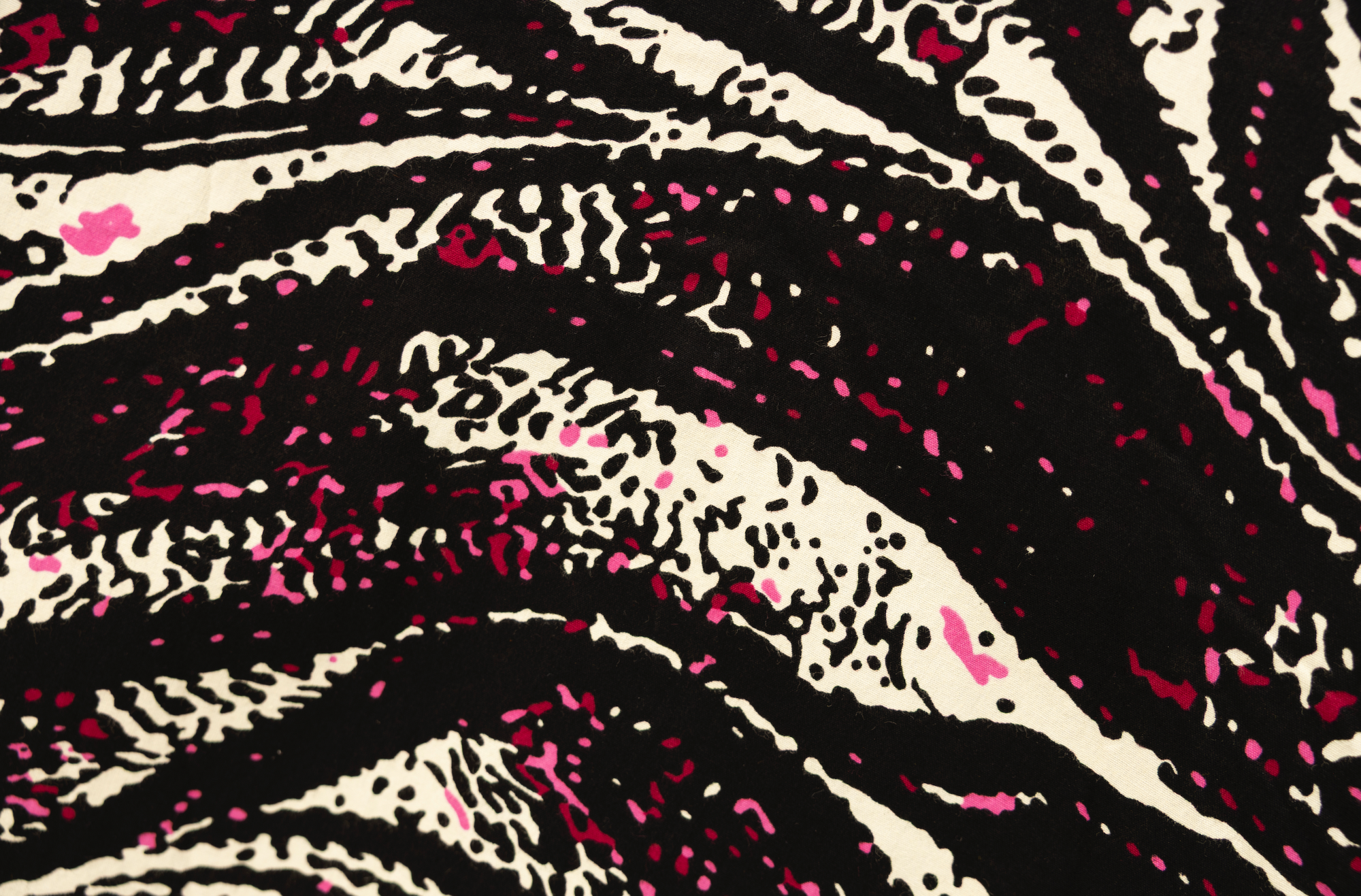 Close up display of pink, black and white glitter print dress, fabric.