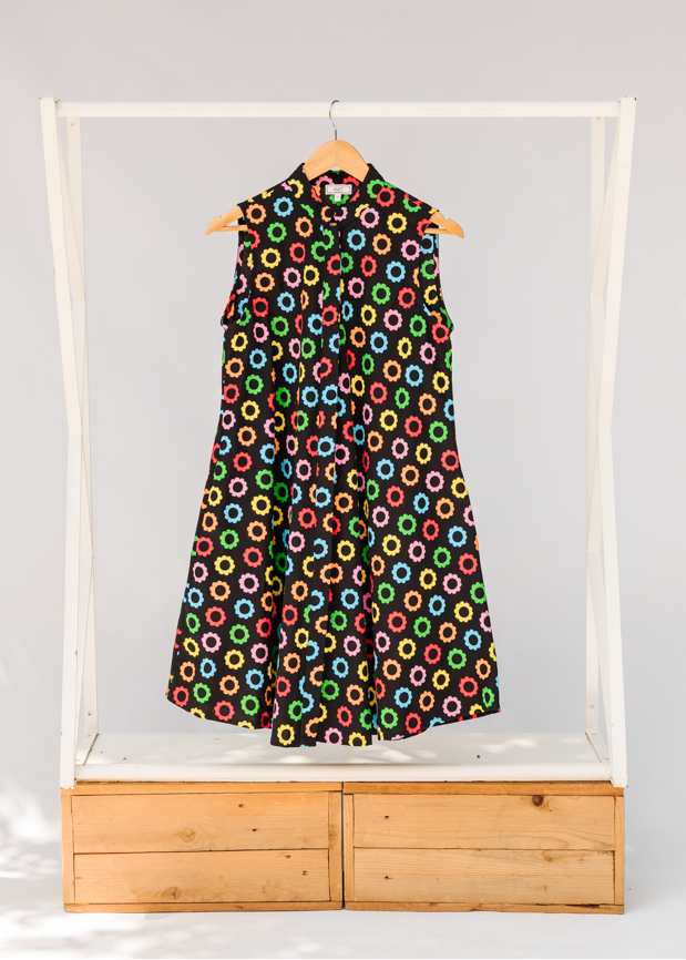 Display of black sleeveless dress with rainbow circle print.