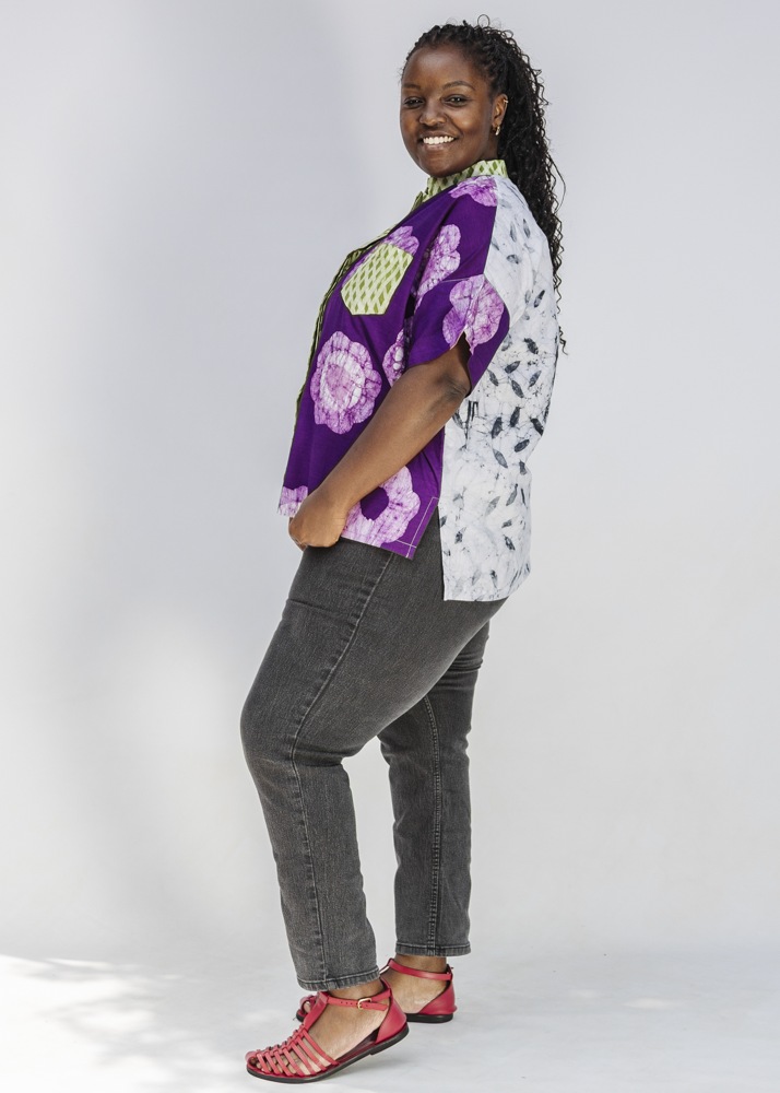 Woman wearing a colorful patterned shirt with a white background