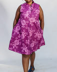 Model wearing purple dress with pink beet print.