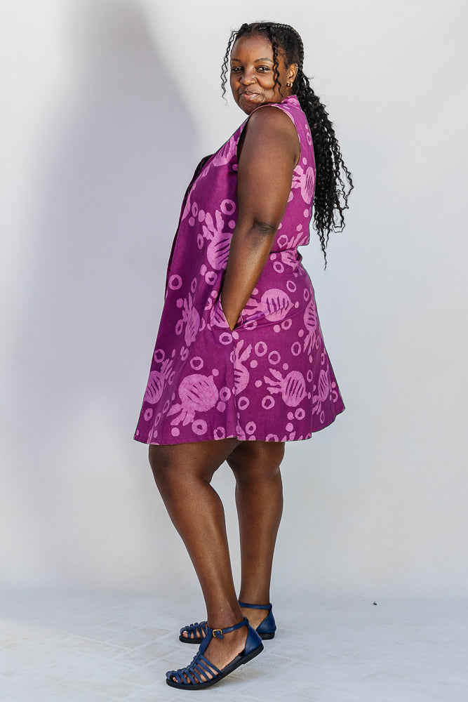 Model wearing purple dress with pink beet print.