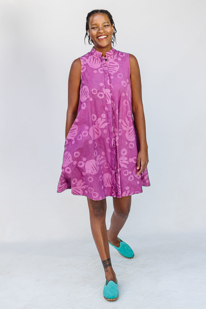 Model wearing purple dress with pink beet print.