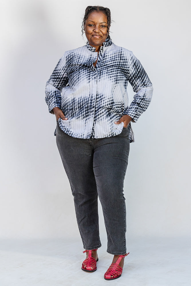 Model wearing white and black batik shirt.