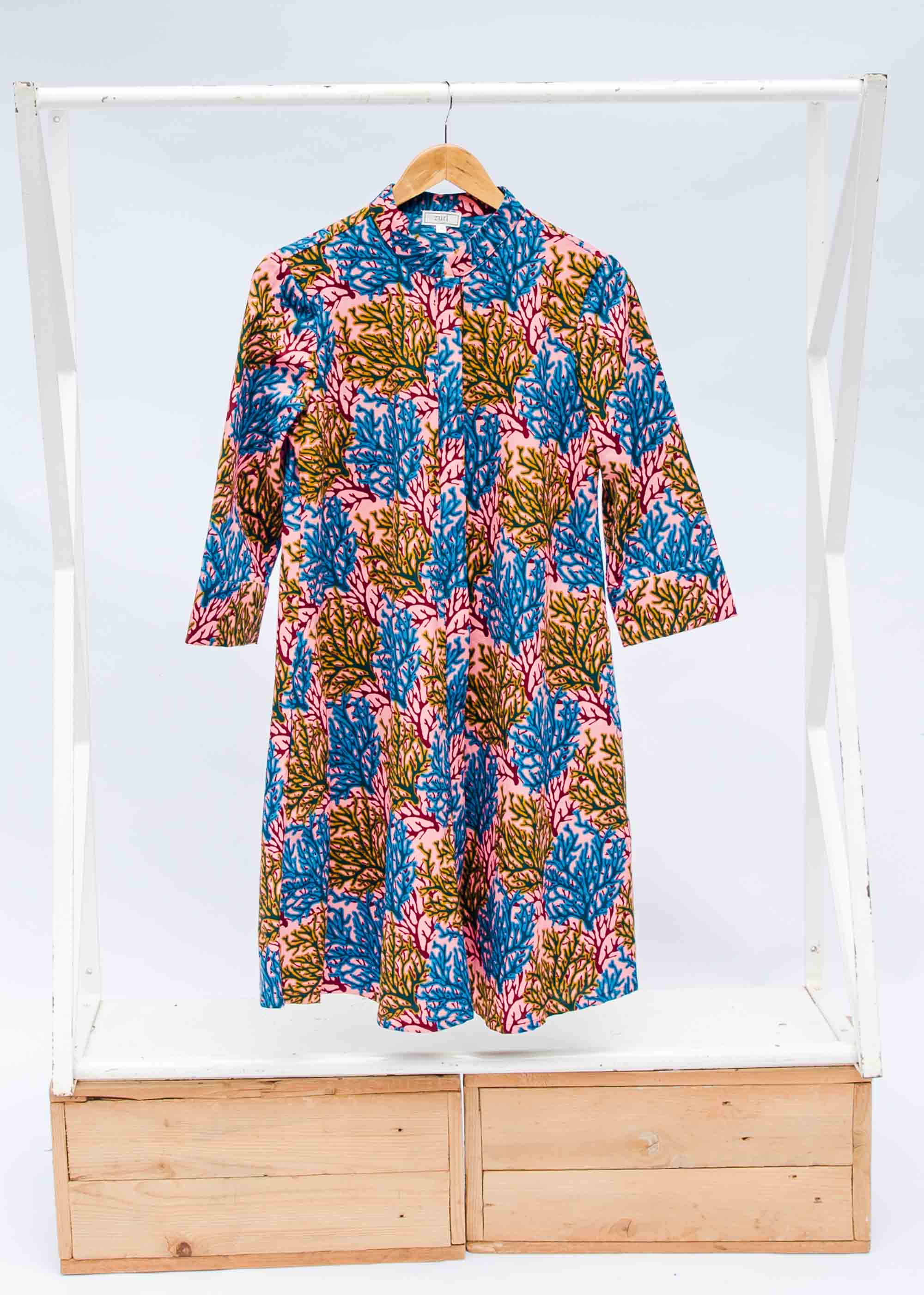 Display of a  blue, yellow and pink coral print shirt dress 