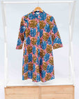 Display of a  blue, yellow and pink coral print shirt dress 