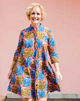 model wearing a  blue, yellow and pink coral print shirt dress 