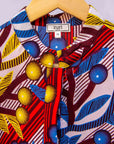 detail of a yellow, red, blue and white vine design shirt dress