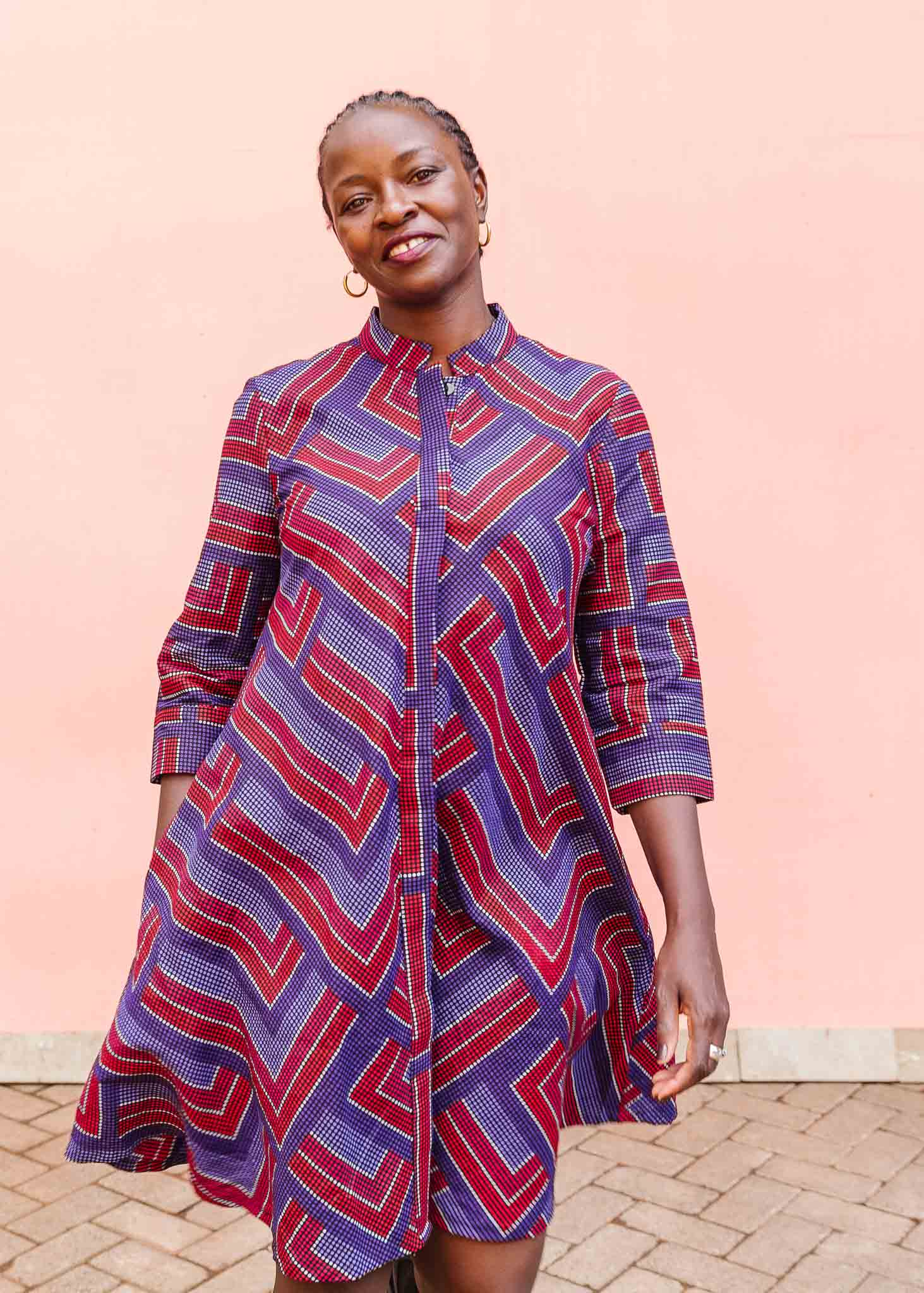 model wearing a blue, red and lavender geometric shirt dress