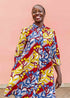 model wearing a yellow, red, blue and white vine design shirt dress