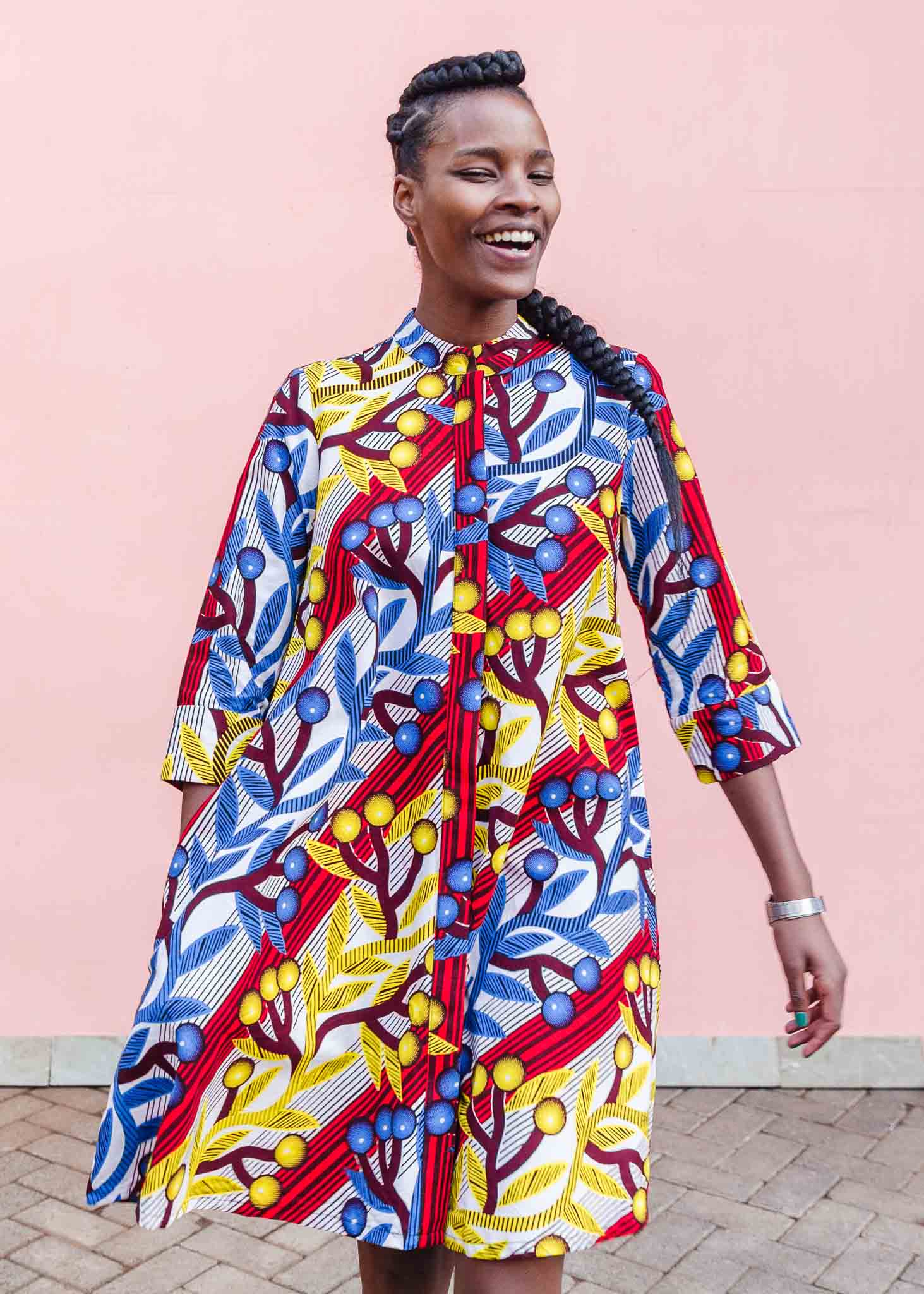 model wearing a yellow, red, blue and white vine design shirt dress
