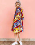 model wearing a yellow, red, blue and white vine design shirt dress