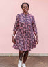 The model is wearing coral, pink, white and navy blue colored dress