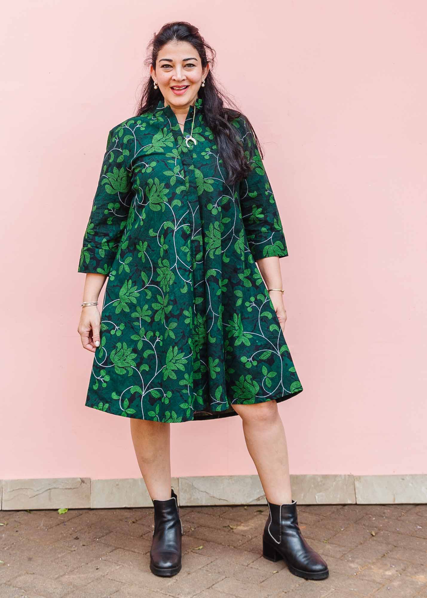 The model is wearing black and forest green dress with lime green and white floral print