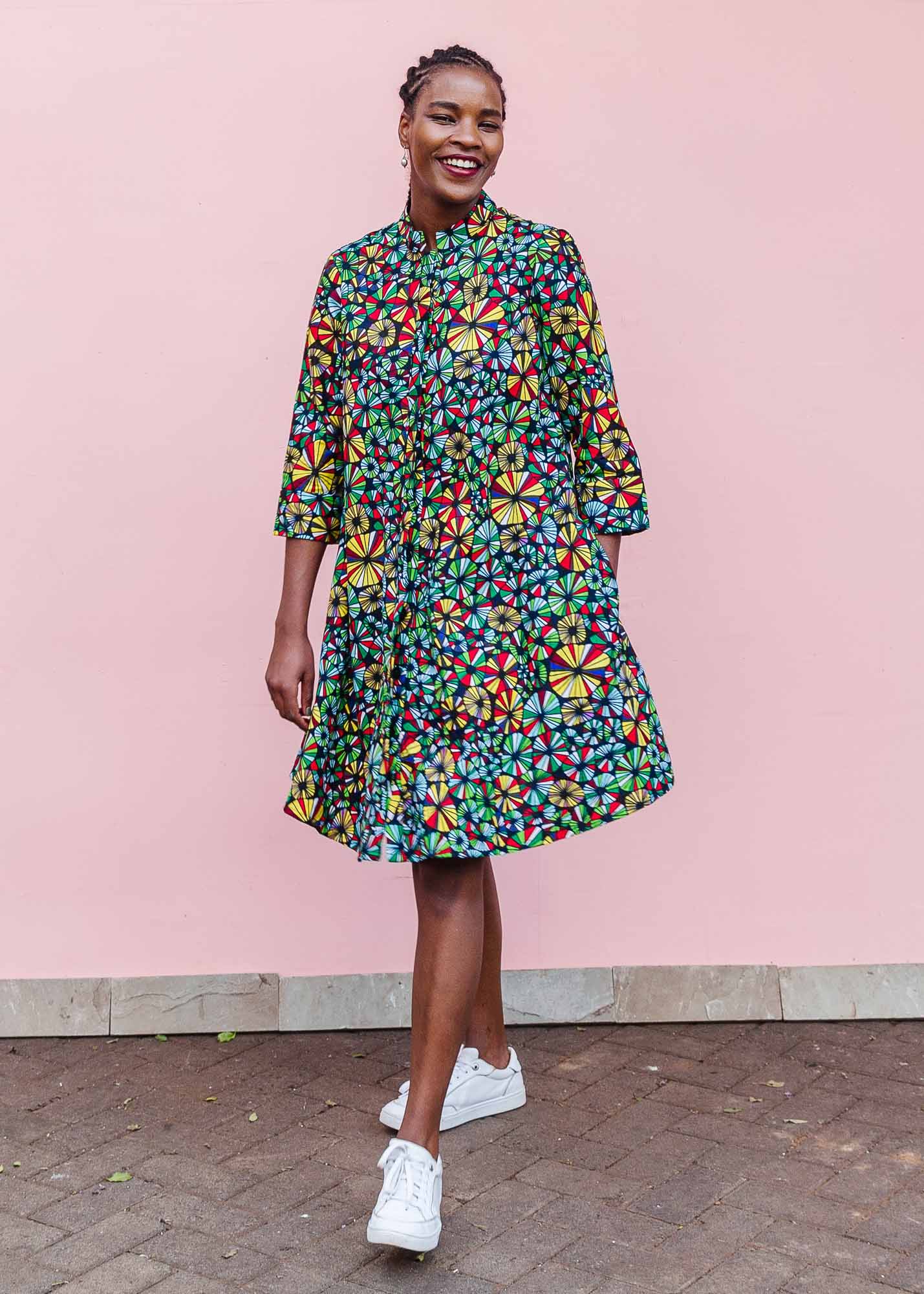 The model is wearing navy blue dress with rainbow color umbrella shaped print 