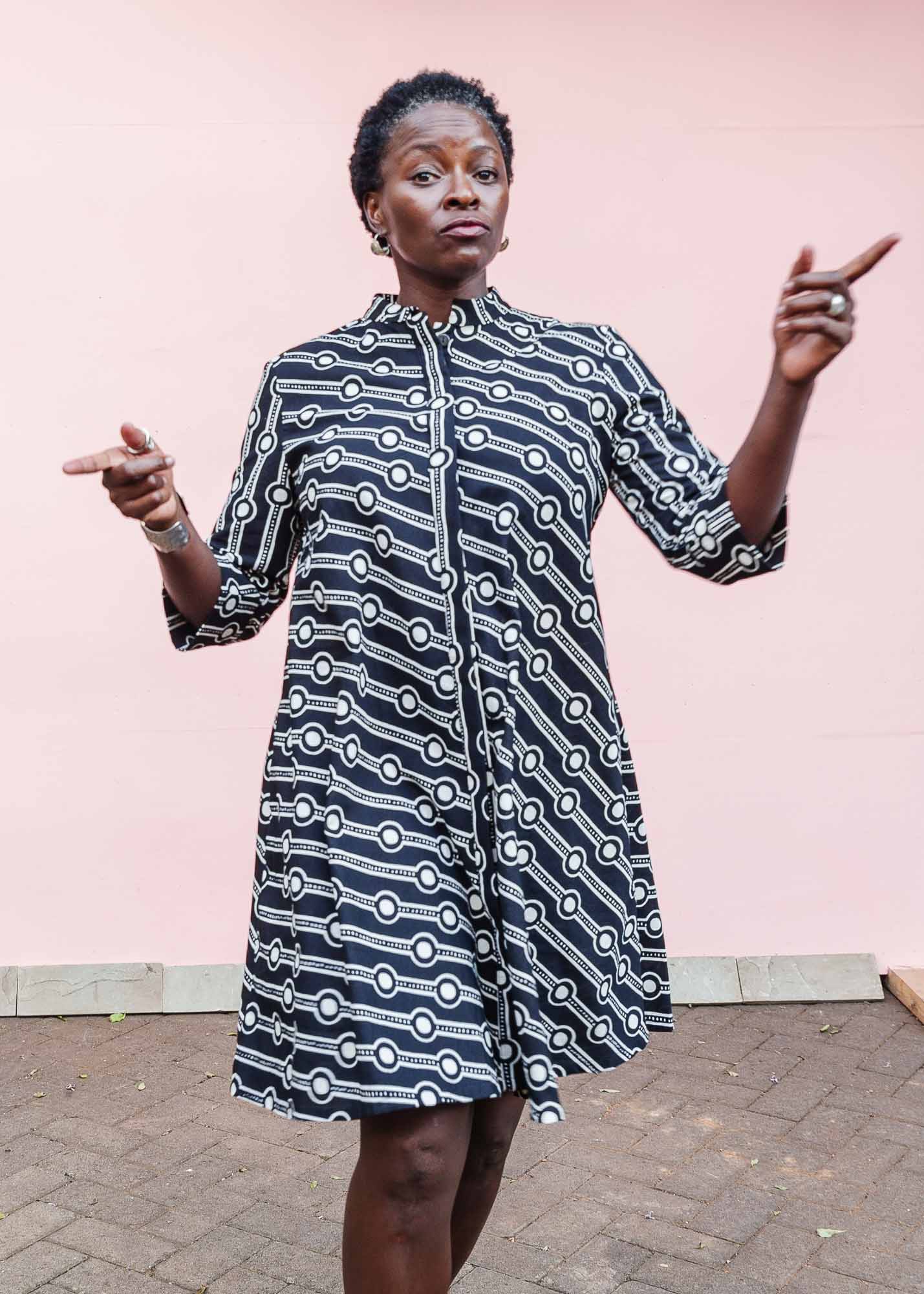 The model is wearing white and black geometric print dress