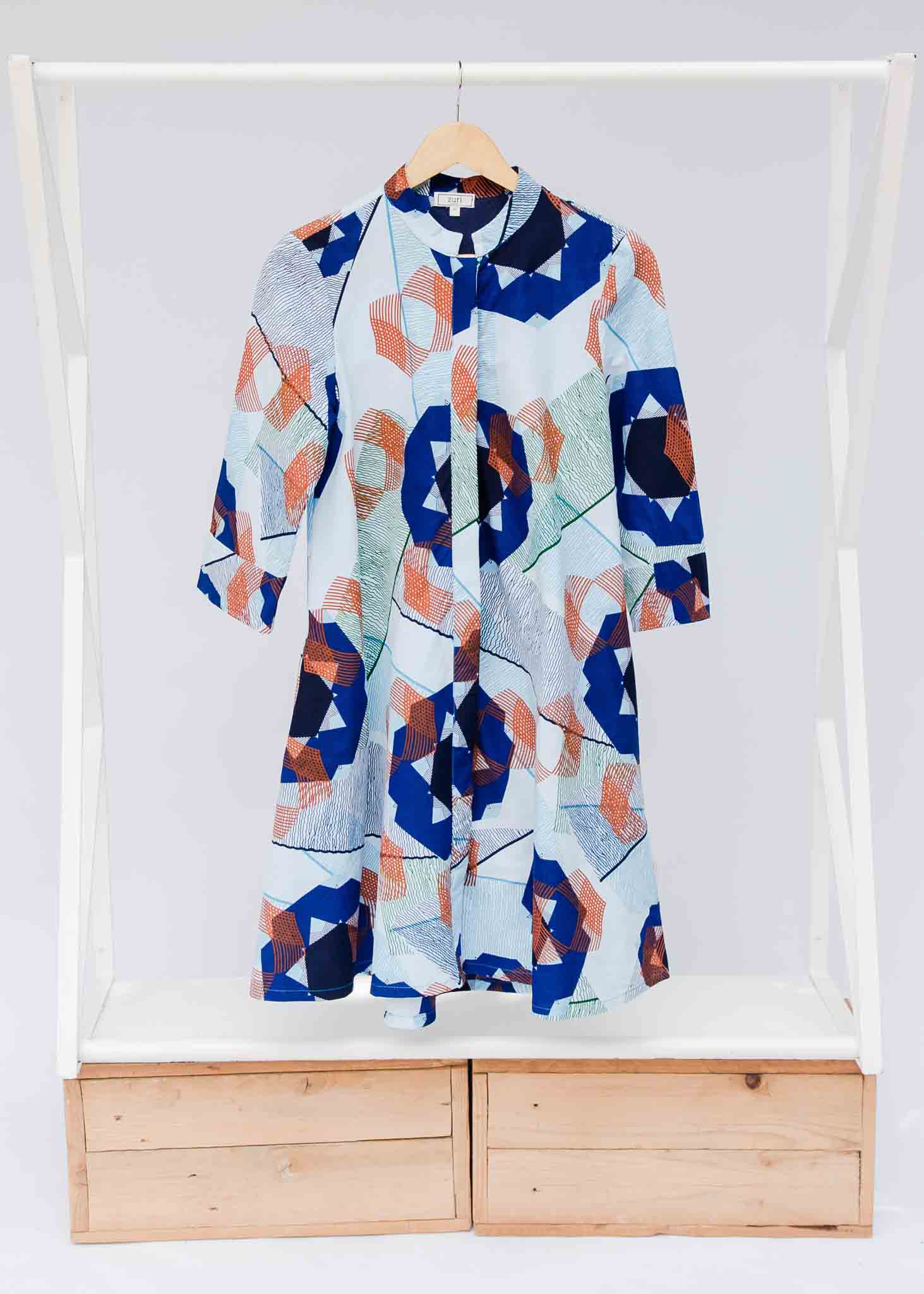 Display of dress with blue, green and orange abstract circular design pattern.