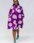 Woman wearing a purple floral dress on a white background