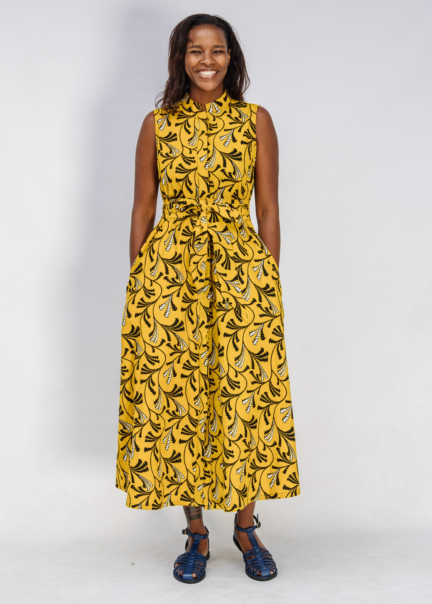 Model wearing yellow dress with black and white paisley print.
