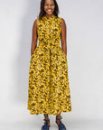 Model wearing yellow dress with black and white paisley print.