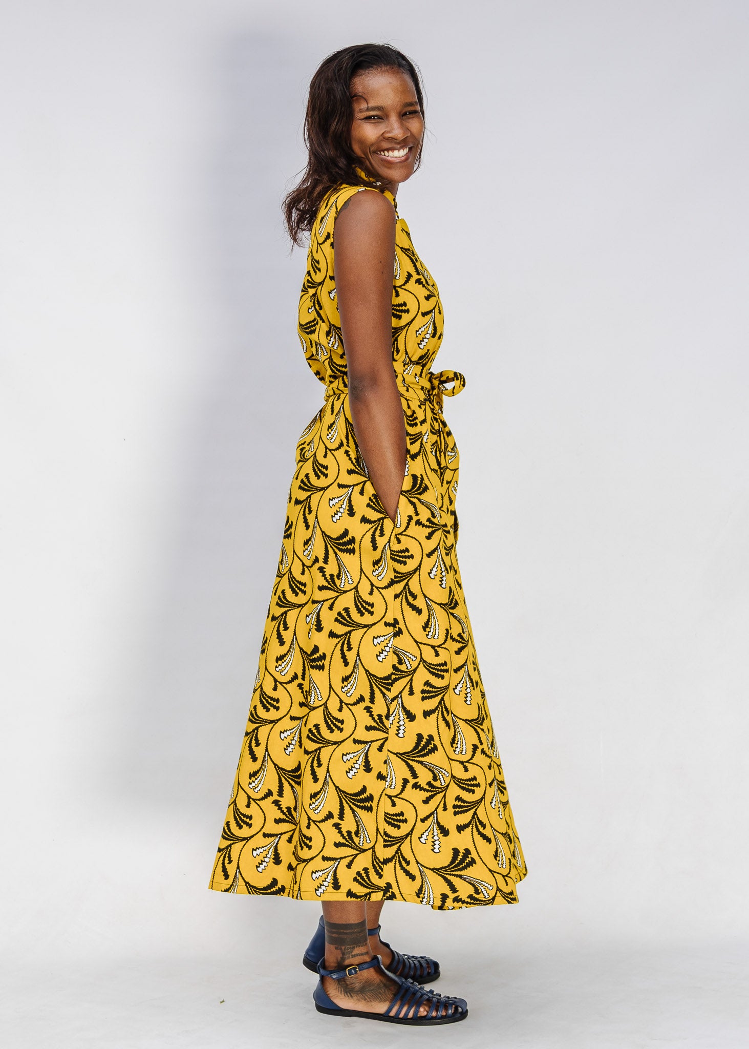 Model wearing yellow dress with black and white paisley print.