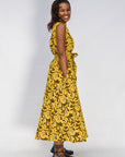 Model wearing yellow dress with black and white paisley print.