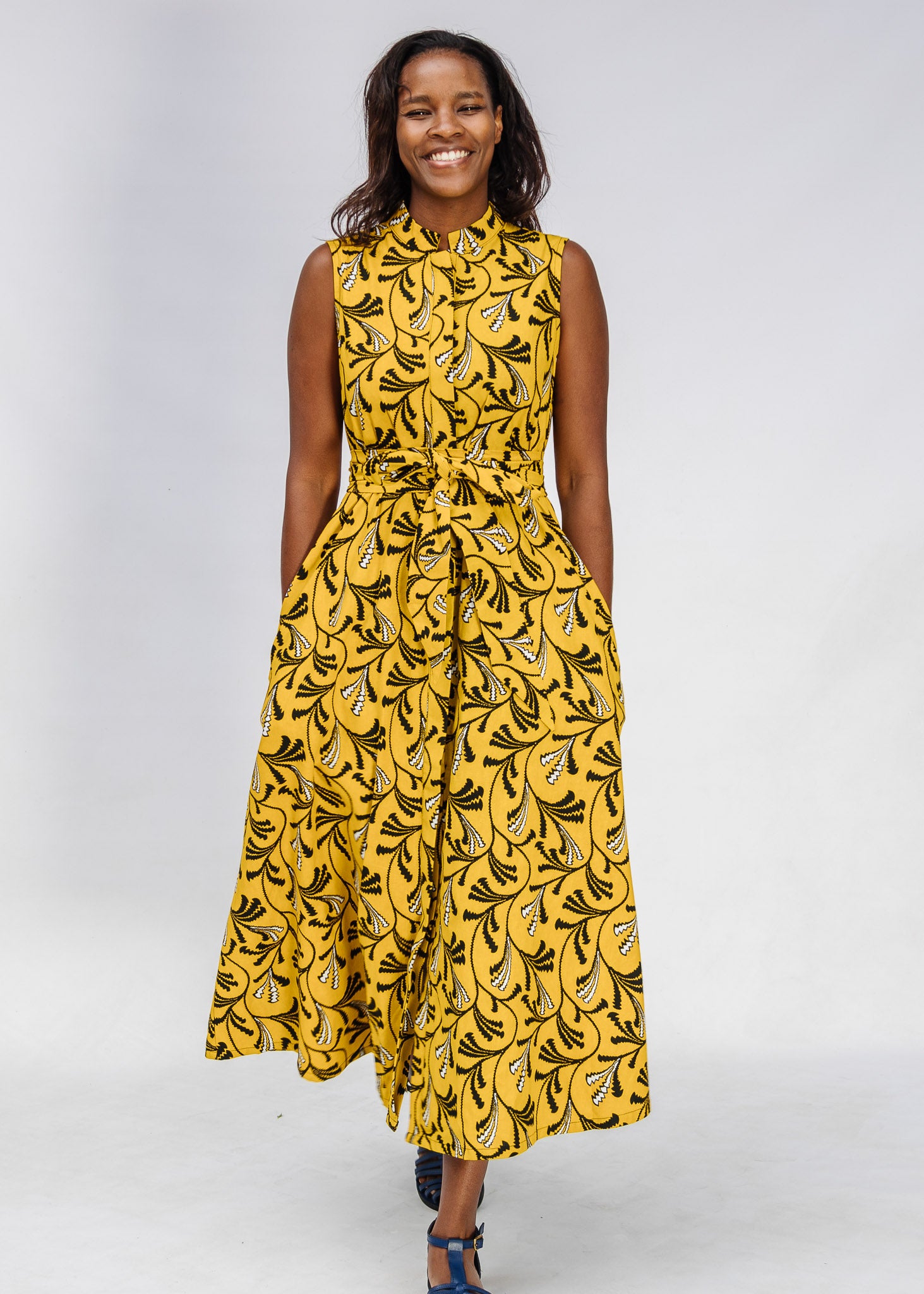 Model wearing yellow dress with black and white paisley print.