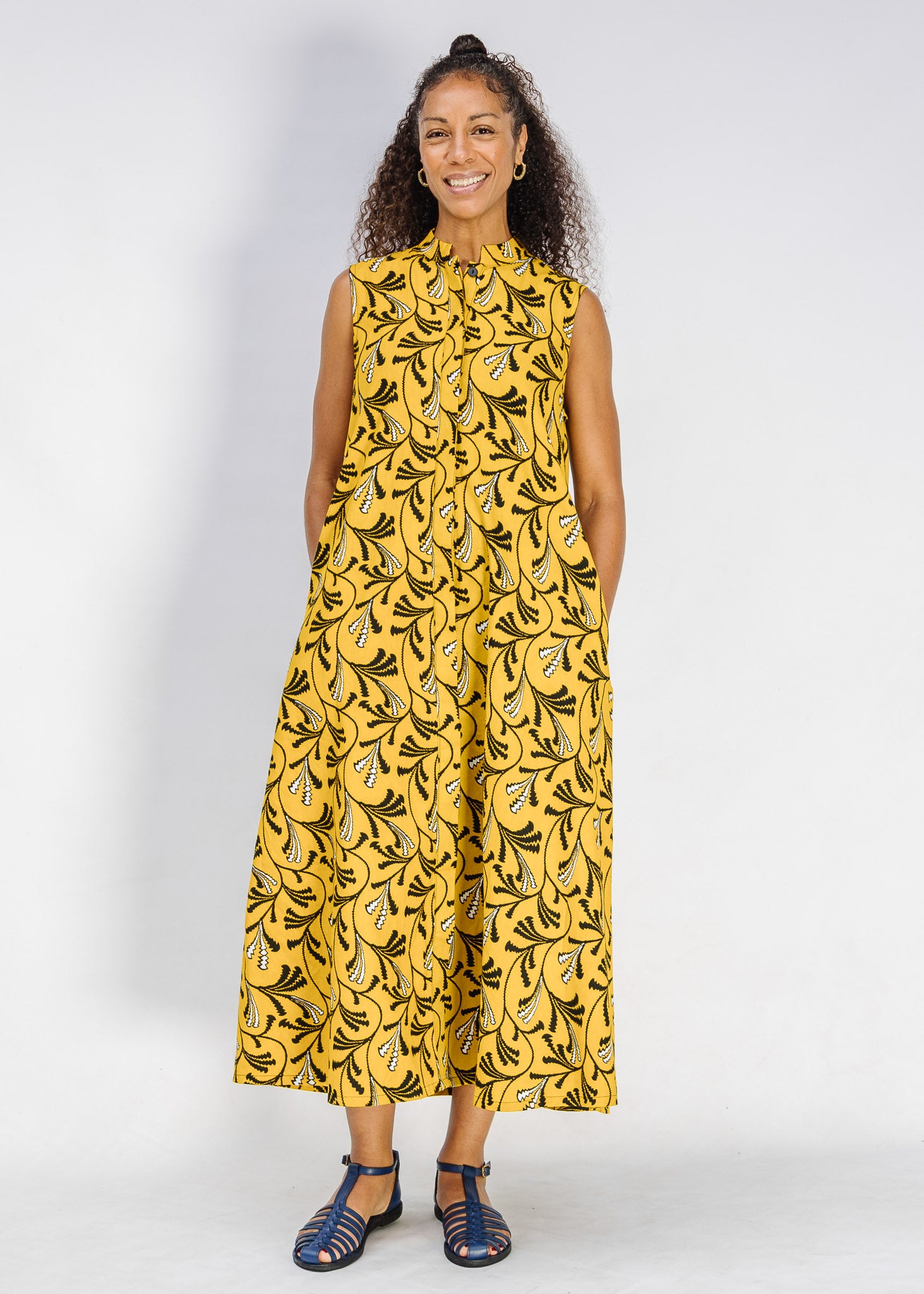 Model wearing yellow dress with black and white paisley print.
