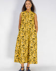 Model wearing yellow dress with black and white paisley print.