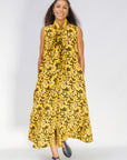 Model wearing yellow dress with black and white paisley print.