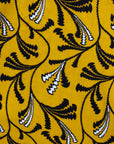 Close up display of yellow dress with black and white paisley print, fabric.