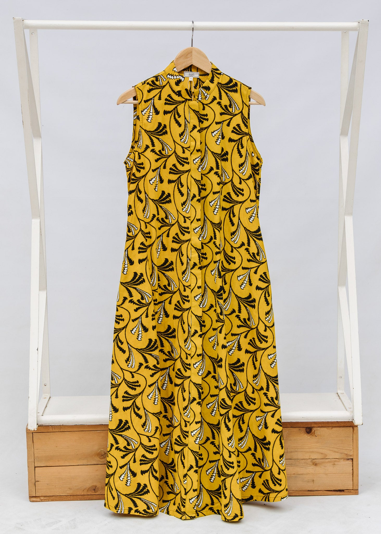 Display of yellow dress with black and white paisley print.