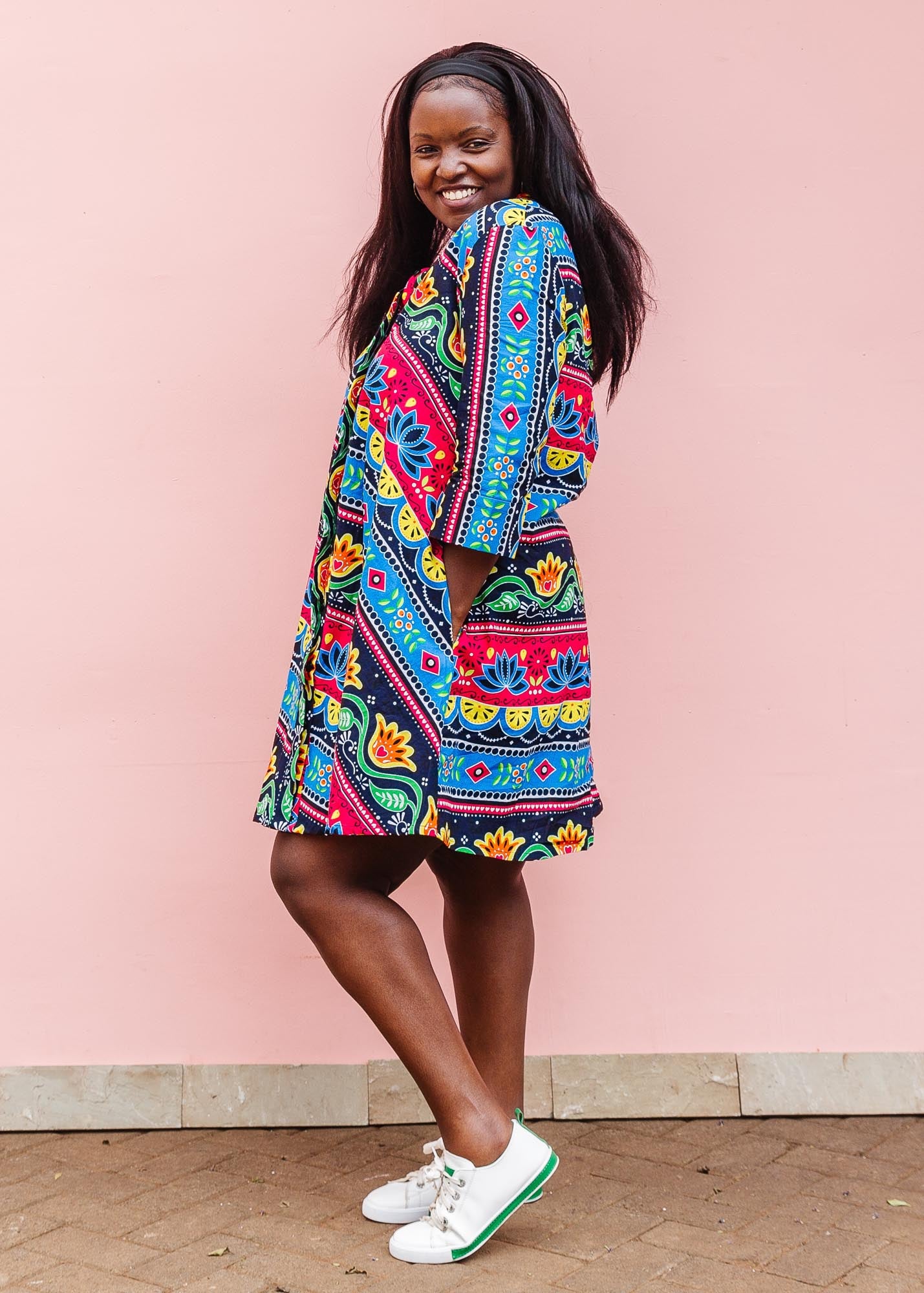 The model is wearing colorful mandala print dress