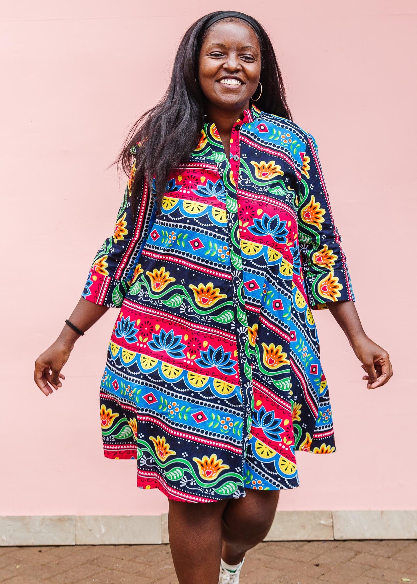 The model is wearing colorful mandala print dress