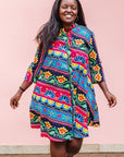 The model is wearing colorful mandala print dress