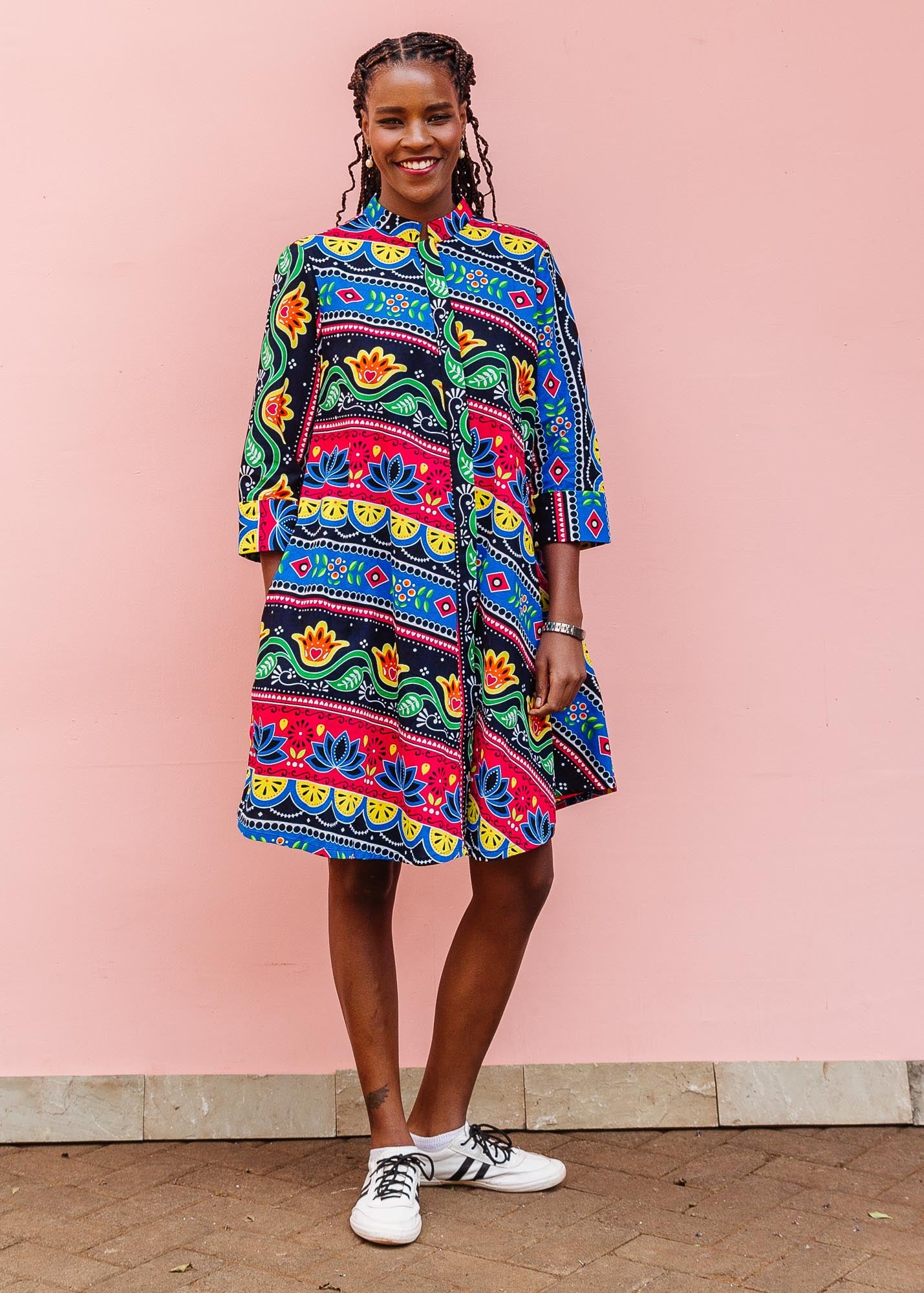 The model is wearing colorful mandala print dress