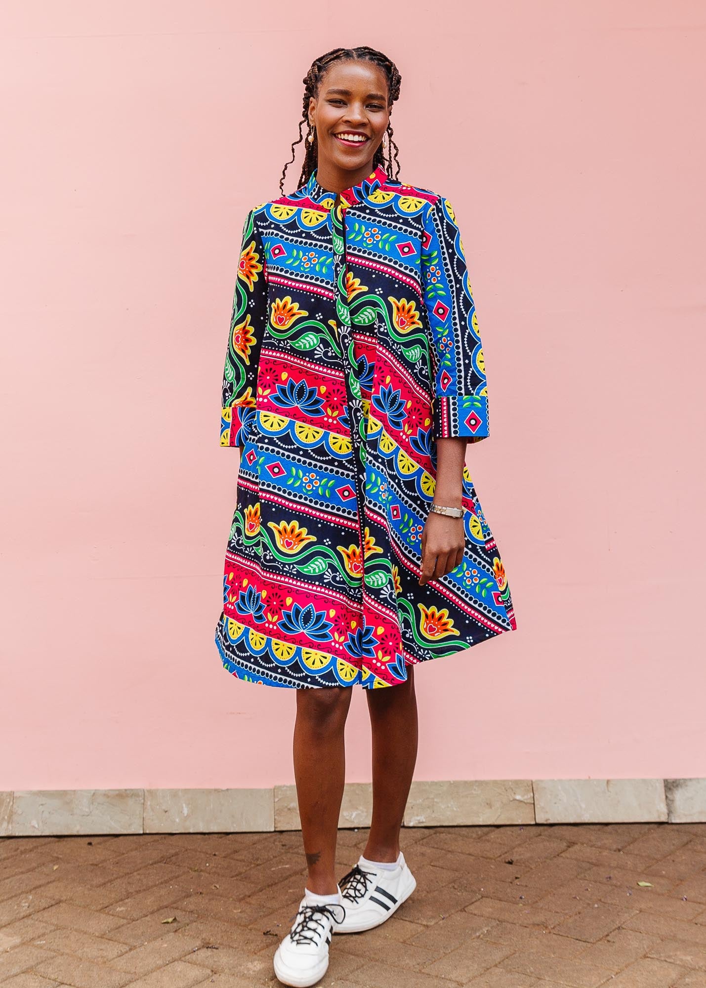 The model is wearing colorful mandala print dress