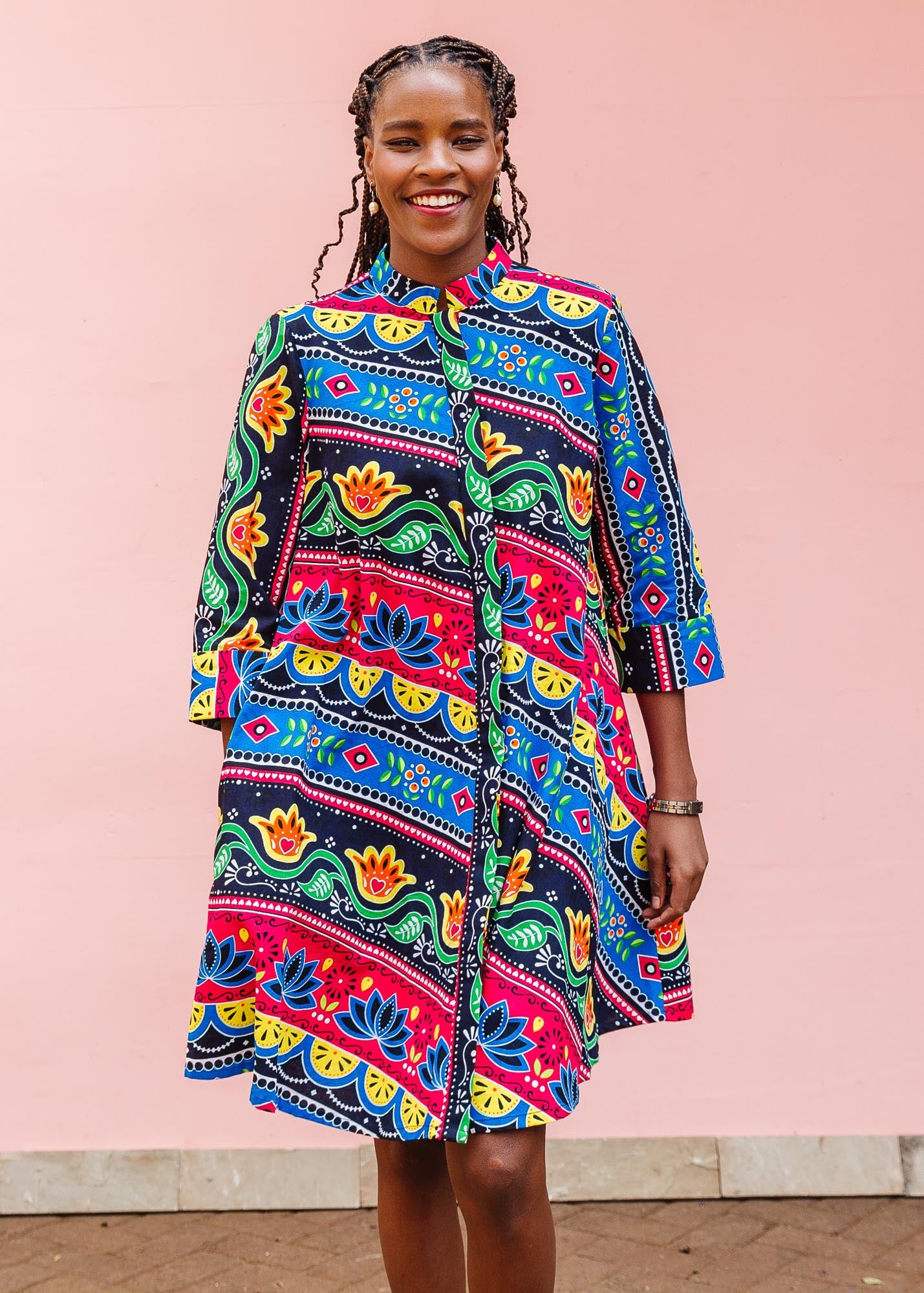 The model is wearing colorful mandala print dress