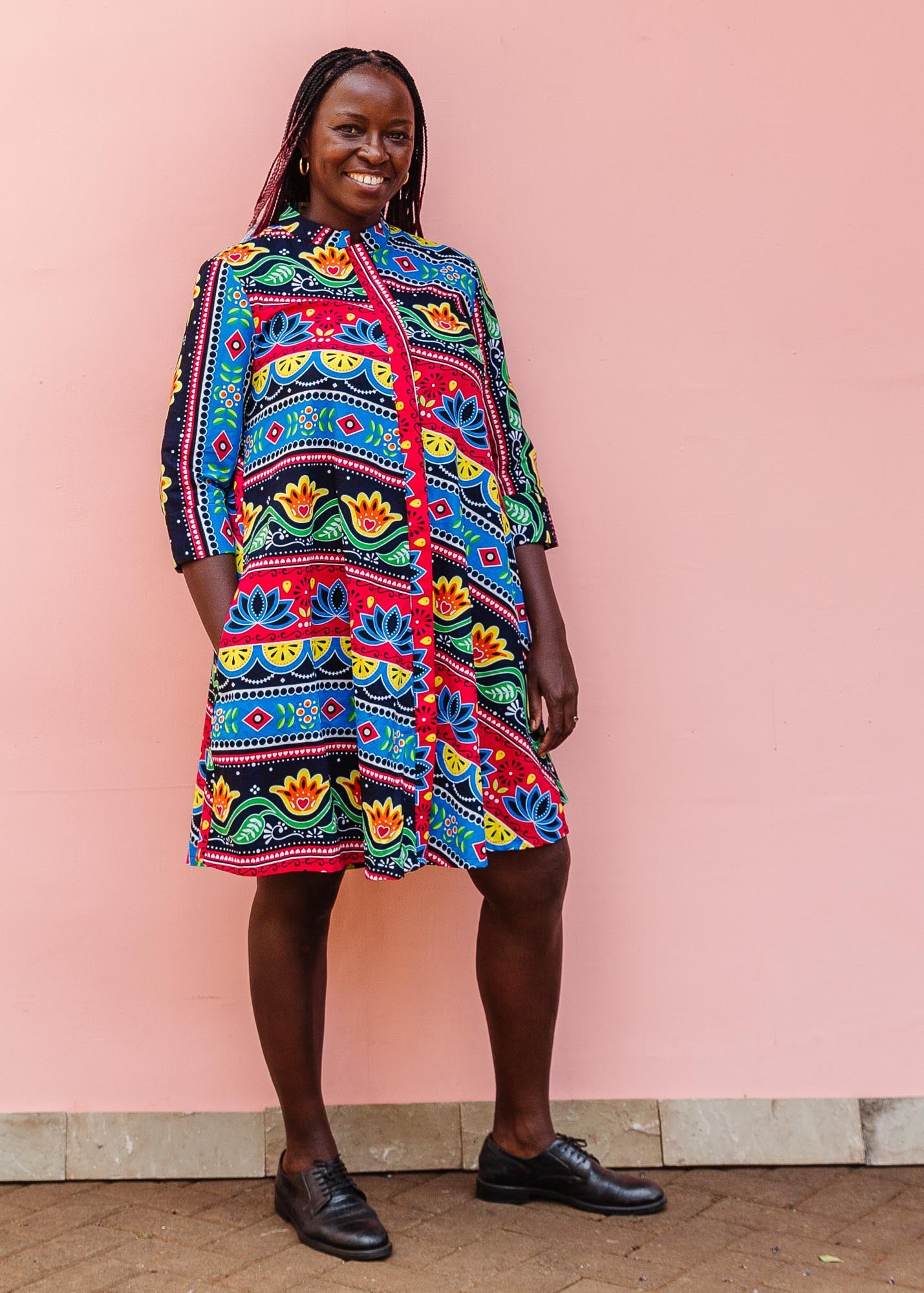 The model is wearing colorful mandala print dress