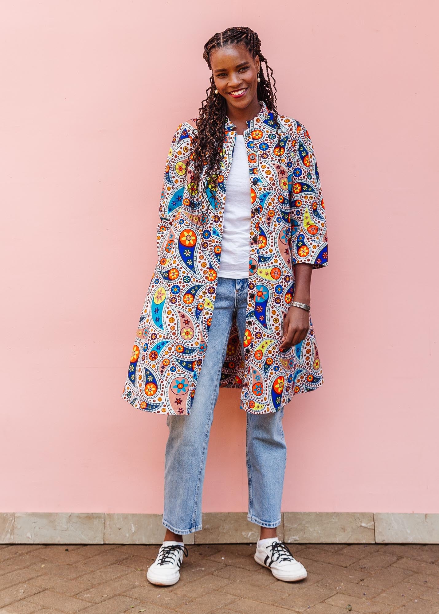 The model is wearing multi-colored paisley print dress